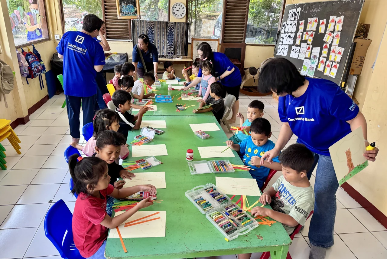 Kinder bei einer kreativen Aktivität mit Volunteers