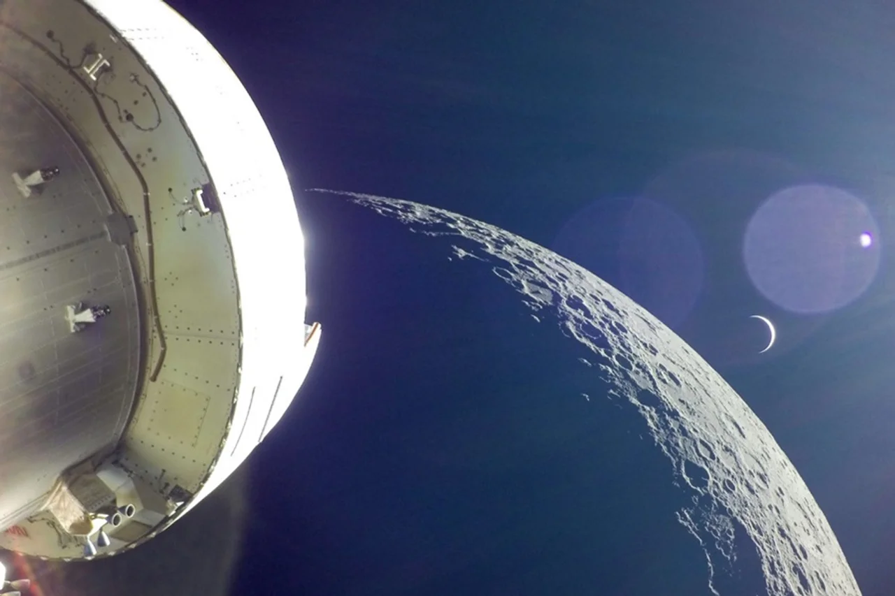 Ein Raumschiff blickt auf den Mond und eine Erdsichel im All.