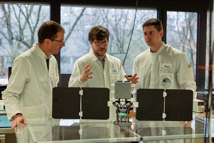 Daiberl und Segert diskutieren an einem Satellitenmodell