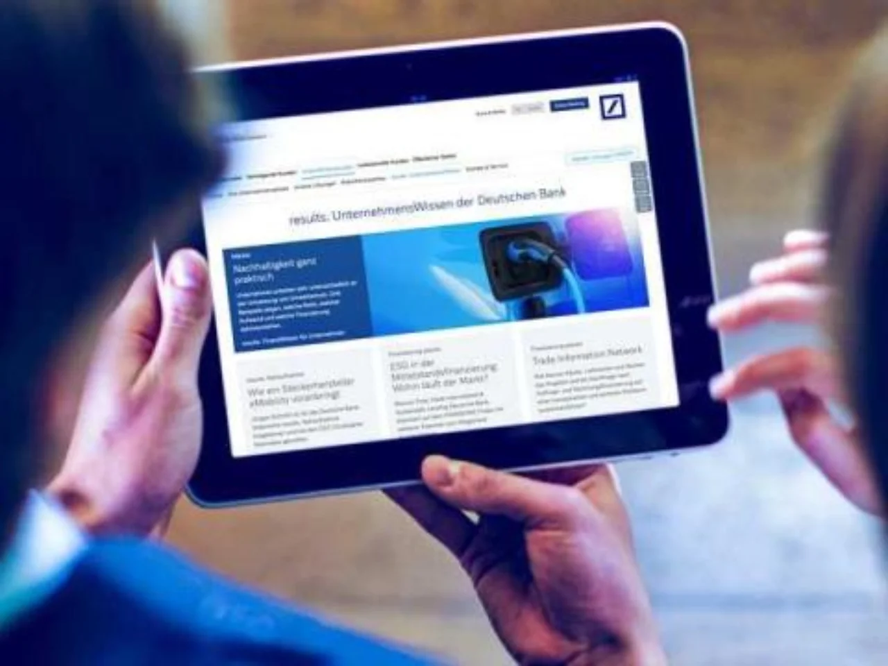 Zwei Personen betrachten „results.“, die Unternehmenswissen-Website.