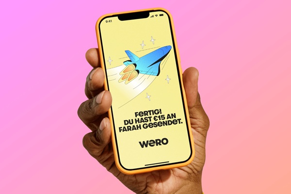 A hand holding a smartphone using the Wero app.